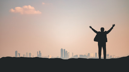 Business man raise hands proud of their business success on the background of the city skyline