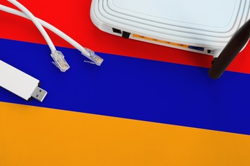 Armenia flag depicted on table with internet rj45 cable, wireless usb wifi adapter and router....
