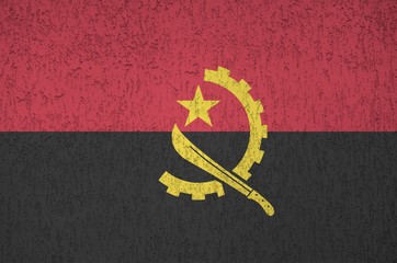 Angola flag depicted in bright paint colors on old relief plastering wall. Textured banner on rough...