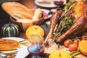 Roasted  chicken or turkey with sauce and grilled autumn vegetables: corn,pumpkin  on wooden table, top view, frame. Christmas or Thanksgiving Day food concept.