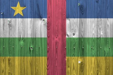 Central African Republic flag depicted in bright paint colors on old wooden wall. Textured banner...
