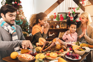 Thanksgiving Celebration Tradition Family Dinner Concept.family having holiday dinner and cutting turkey.Young black adult woman and her daughter happy.