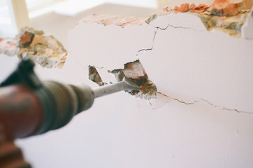 Professional worker in construction site using jackhammer