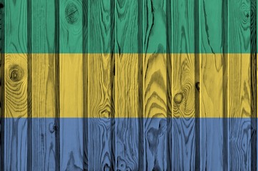 Gabon flag depicted in bright paint colors on old wooden wall. Textured banner on rough background