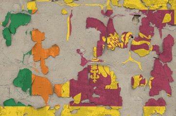 Sri Lanka flag depicted in paint colors on old obsolete messy concrete wall closeup. Textured banner on rough background