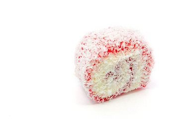 Red Turkish delight roll sprinkled with coconut flakes closeup on a white background isolated.