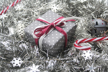 Christmas festive background with silver decorations and a gift box and candy canes