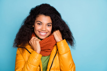 Closeup photo of pretty dark skin wavy lady enjoy autumn weather outside warm clothes wear yellow fall overcoat sweater knitted scarf isolated blue color background © deagreez