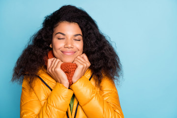Closeup photo of beautiful dark skin wavy lady enjoy autumn weather outside and warm clothes wear yellow fall overcoat sweater knitted scarf isolated blue color background © deagreez