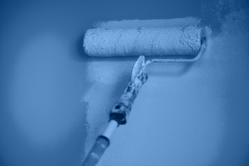 Hand painting wall with paint roller in monochrome color. Appartment renovation, repair, building...
