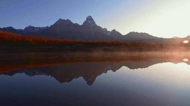Morning view of fog over a lake with Mt. Ushba mountain in Caucasus, Georgia, pan left