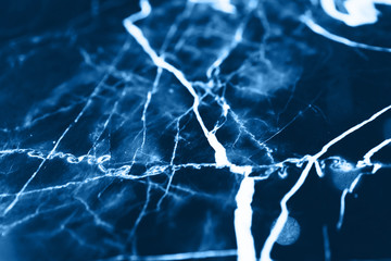 White and blue patterns on black marble background. Copy space for text.