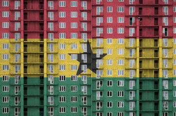 Ghana flag depicted in paint colors on multi-storey residental building under construction....