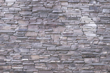 Gray stone wall background. Light texture of masonry, rough surface, modern design. Natural pattern. Abstract architecture backgrounds. Brown textured facade of building.