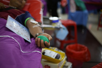 Blood donor at donation with a bouncy ball holding in hand, image for Thai Nov 2019