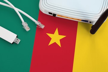 Cameroon flag depicted on table with internet rj45 cable, wireless usb wifi adapter and router....