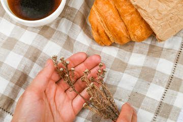 morning with a croissant. the beginning of the morning. Fresh french croissant. Coffee cup and fresh baked croissants on a wooden background. View from above. Morning breakfast with croissant and coff