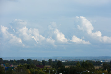 White and thick clouds in a blue sky. Cloudy sky and horizon.