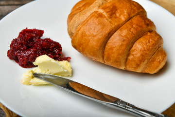 morning with a croissant. the beginning of the morning. Fresh french croissant. Coffee cup and fresh baked croissants on a wooden background. View from above. Morning breakfast with croissant and coff