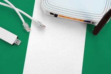 Nigeria flag depicted on table with internet rj45 cable, wireless usb wifi adapter and router....