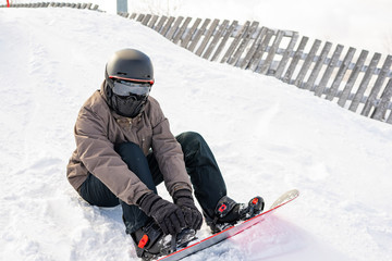 Fototapeta na wymiar Active man snowboarder riding on slope. Snowboarding closeup.