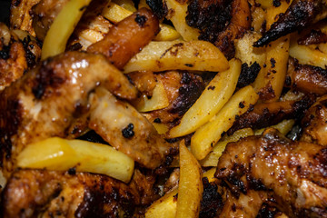 Chicken wings marinated with spices fried in a pan with potatoes. Home cooking