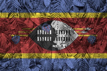 Swaziland flag depicted on many leafs of monstera palm trees. Trendy fashionable backdrop