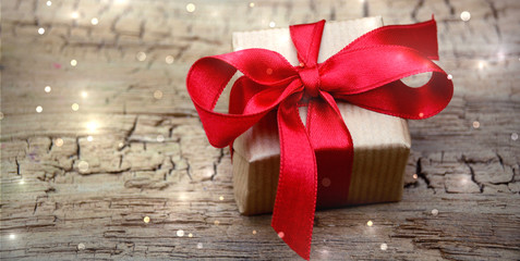 Geschenk Box mit roter Schleife auf rustikalem Holzuntergrund - Weihnachten Hintergrund Banner...