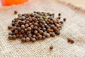 black pepper granules scattered on burlap
