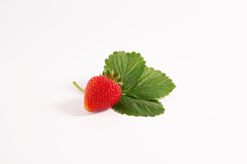 It is a red ripe strawberry berry and a green leaf on a white background