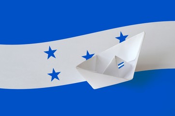 Honduras flag depicted on paper origami ship closeup. Handmade arts concept