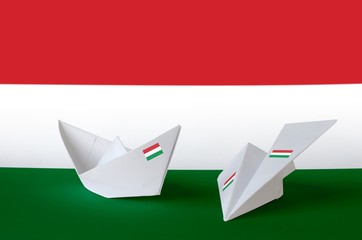Hungary flag depicted on paper origami airplane and boat. Handmade arts concept