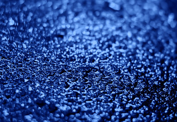 Spectacular texture with bright spots on wet asphalt. Blue.