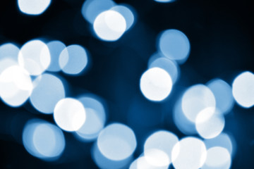 Obraz premium Classic blue lights bokeh background, Chrismas lights bokeh. Classic blue abstract background. Blurred and glowing lights. Classic blue bokeh lens effect from lighting spots.