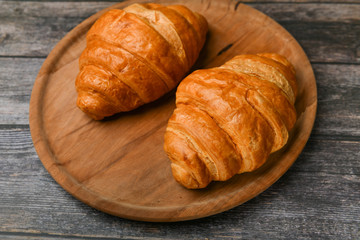 two croissants. Fresh french croissant. on a wooden background. View from above. Morning breakfast with a croissant. French breakfast. Great homey. Fresh tower.