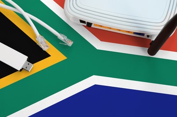 South Africa flag depicted on table with internet rj45 cable, wireless usb wifi adapter and router....