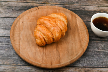 croissant closeup. Fresh french croissant. To on a wooden background. View from above. Morning breakfast with a croissant. French breakfast