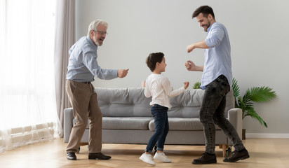 Full-length three generations of men dancing in living room