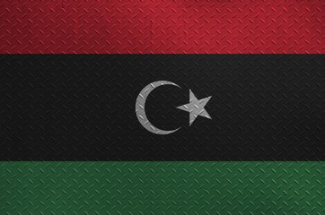 Libya flag depicted in paint colors on old brushed metal plate or wall closeup. Textured banner on...