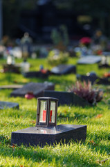 lantern on a gravestone of a cemetery with pauper graves against blurred background