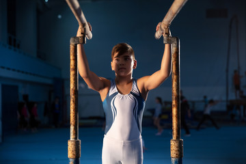 Little male gymnast training in gym, flexible and active. Caucasian fit little boy, athlete in...