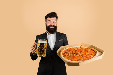 Restaurant or pizzeria. Smiling man with beard holds delicious pizza in box and cold beer. Fast food. Italian food. Bearded man with tasty pizza and beer in hands. Pizza time. Pizza delivery concept.