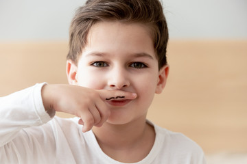 Boy like adult drew moustache on finger put over lips