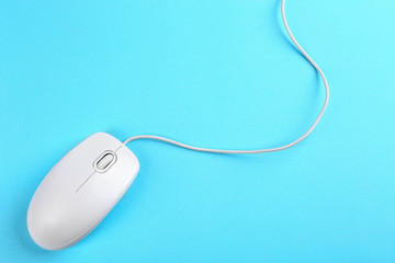 Modern wired mouse on light blue background, top view