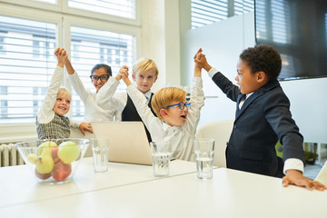 Kinder als erfolgreiches Business Team beim Jubeln