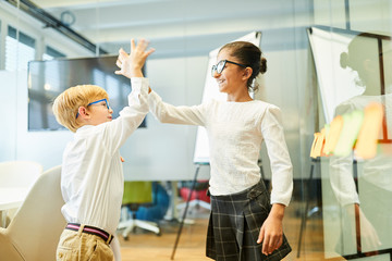 Business Kinder feiern einen Deal mit High Five