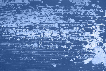 Old silver metal wall with peeled off and scratched trendy blue paint. Color trend of 2020.