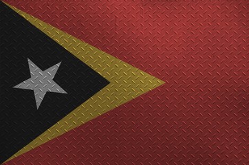 Timor Leste flag depicted in paint colors on old brushed metal plate or wall closeup. Textured...