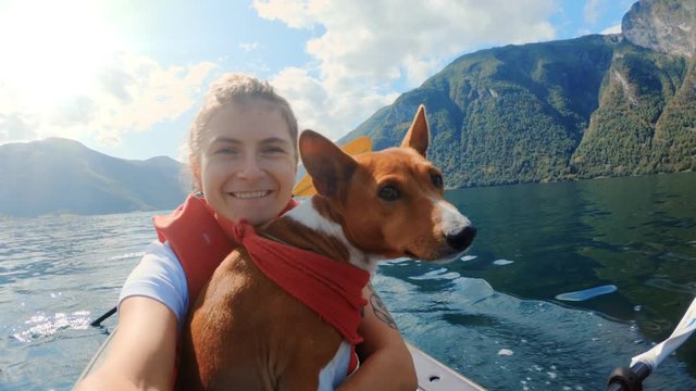 Happy girl traveller on kayak with cute dog