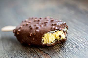 Bitten ice cream popsicle covered with chocolate